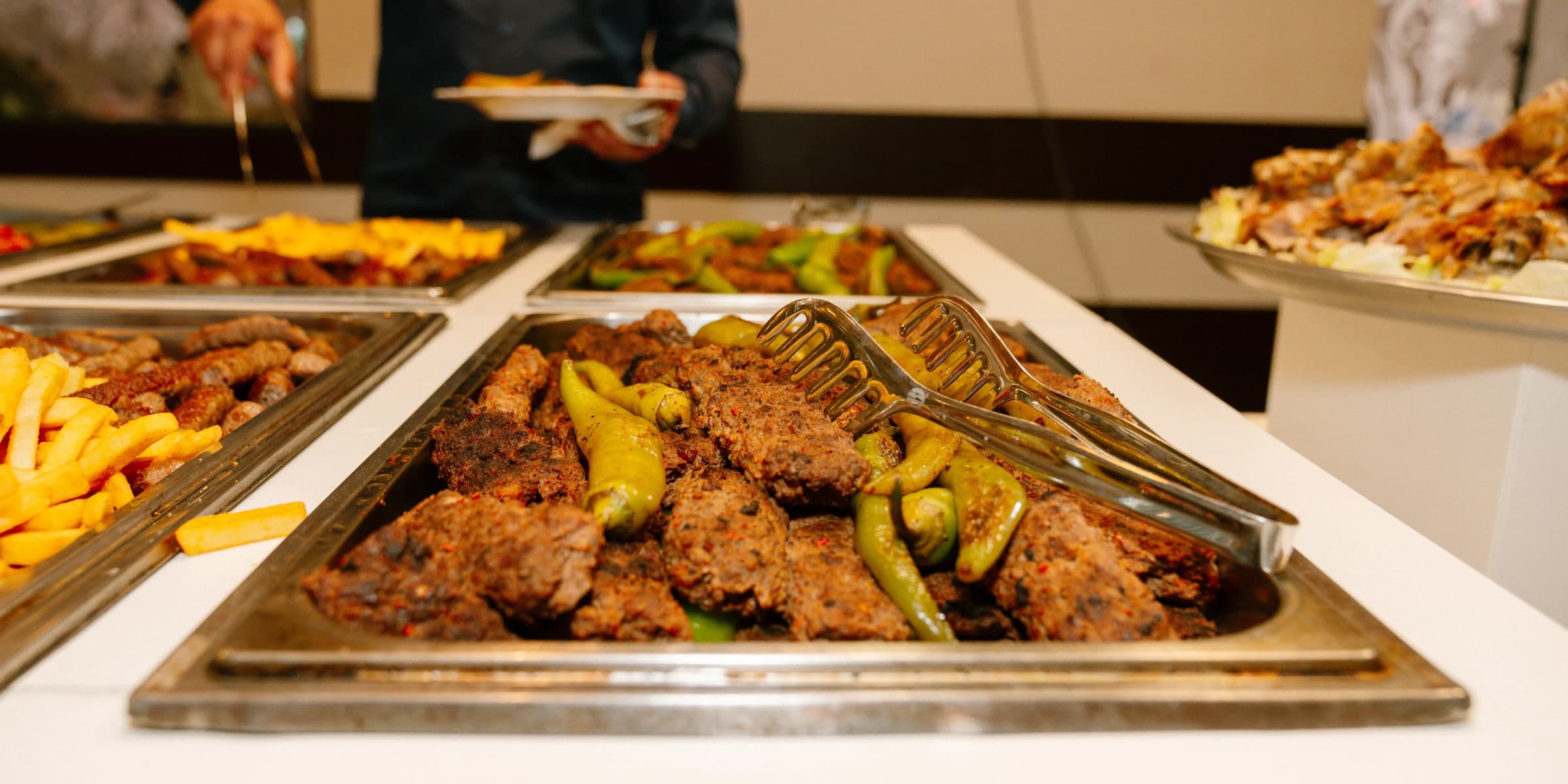 Catering-Buffet von AHUEVENT mit warmen Grillspezialitäten, Paprika und Beilagen im Festsaal